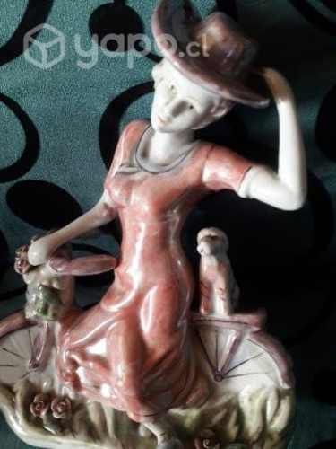 Estatuilla porcelana dama en bici con mascota