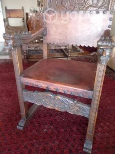 Sitial antiguo de madera labrada y cuero.