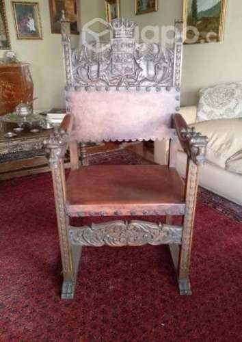 Sitial antiguo de madera labrada y cuero.