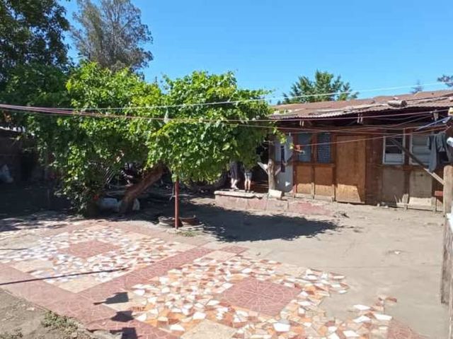 EN MOLINA: Céntrico terreno con casa habitaciión.