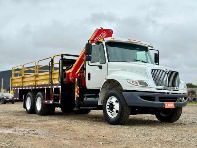2015 Camión Pluma International 4400 con Pluma FASSI F235 para 4.000 kgs al lado con carrocería barandas.
